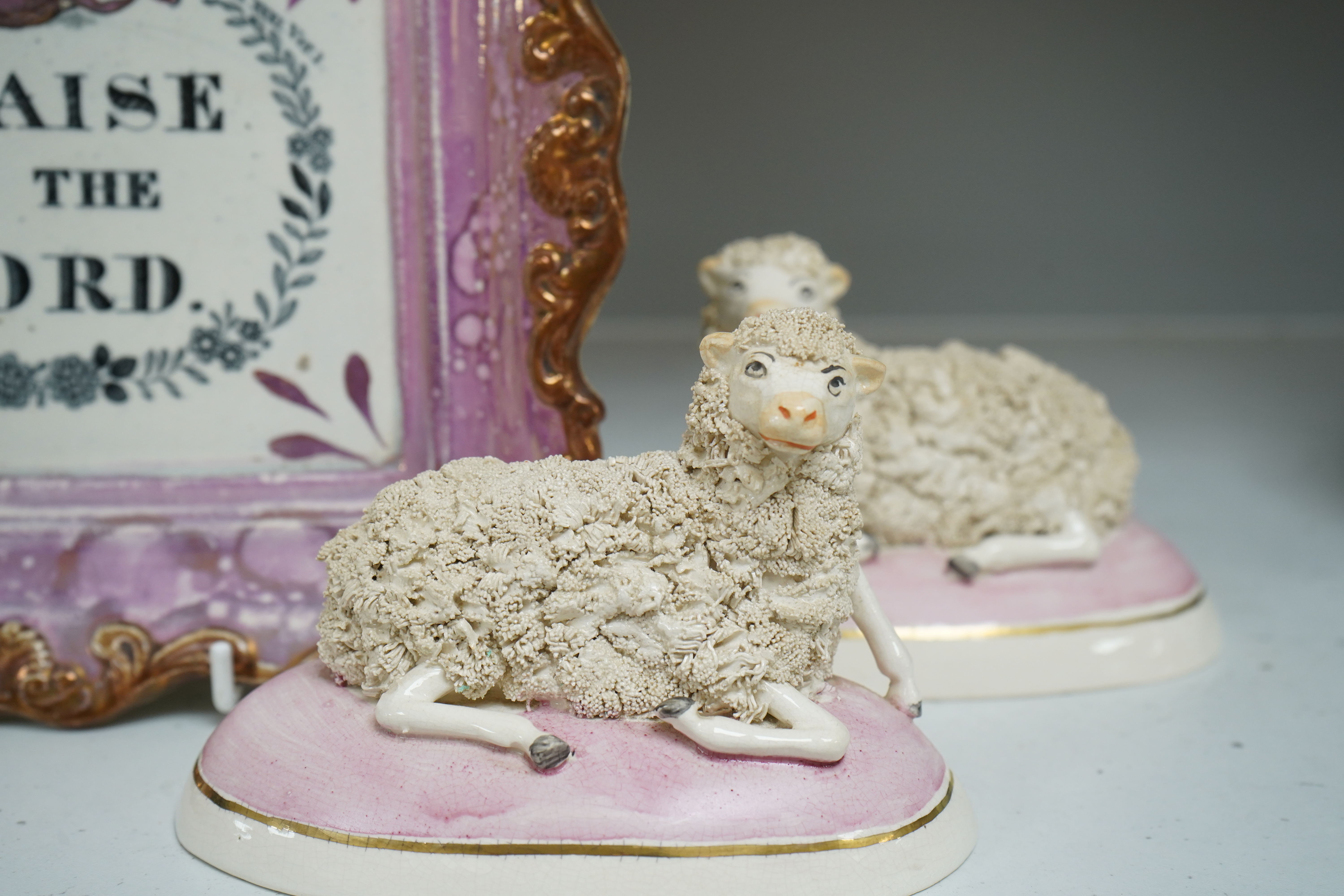 An 19th century Sunderland pink lustre wall plaque and two Staffordshire-style models of recumbent sheep, dish 24cm wide. Condition - good